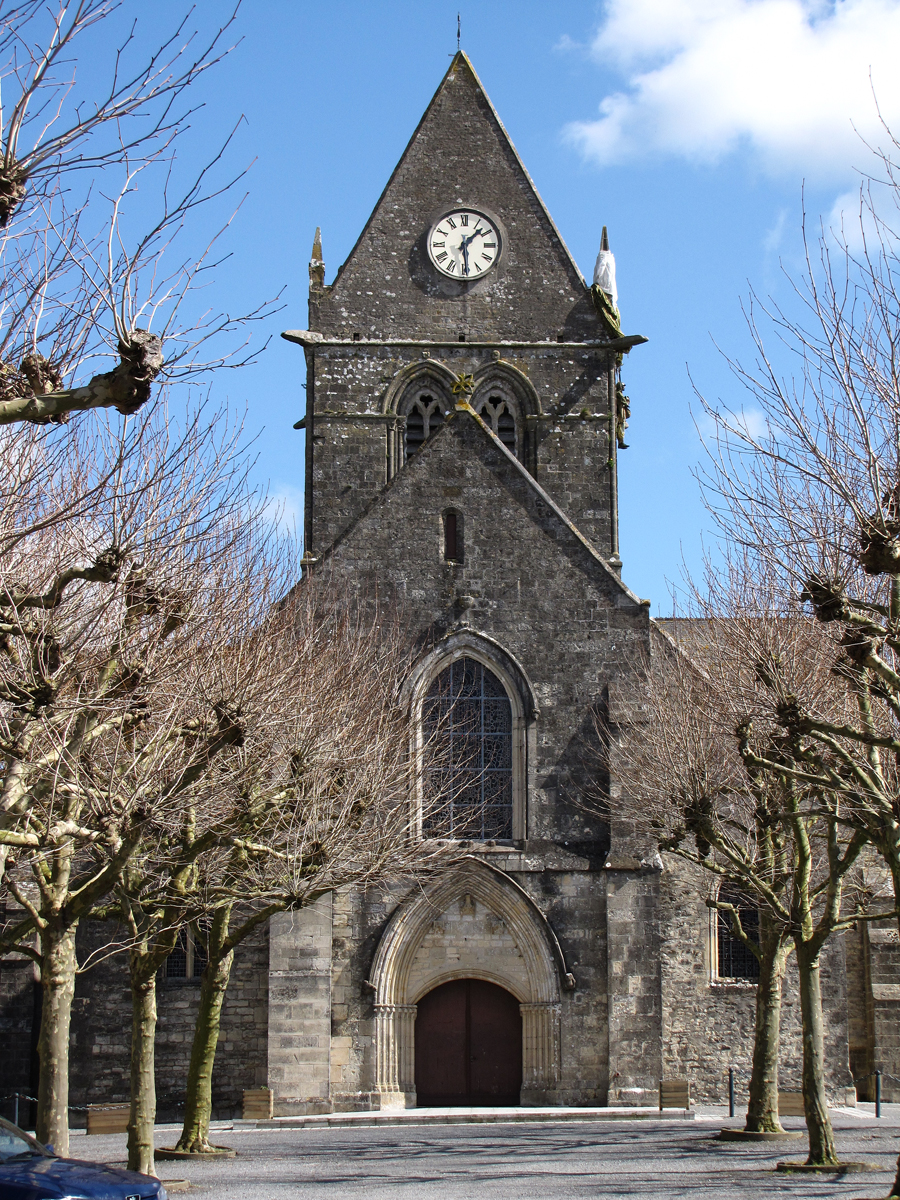 Private John Steele, a member of the 82nd Airborne drifted into St. Mere Eglise where his parachute became entangled in the spires of the church. He survived the ordeal and went on to fight. To this day, there is a manikin and a parachute hanging from the church to commemorate the event.